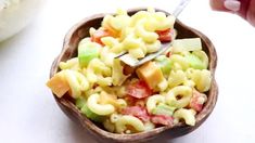 a wooden bowl filled with macaroni salad