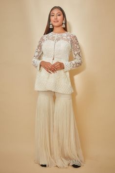 White peplum jacket with cutdana, sequins and beaded hand embroidered floral motifs. Comes with sharara.
Components: 2
Pattern: Hand embroidered
Type Of Work: Cutdana, Sequins, Beads
Neckline: Round
Sleeve Type: Sheer Sleeves
Fabric: Georgette, Tulle
Color: White
Other Details: 
Closure : Jacket - Front hooks
Occasion: Sangeet - Aza Fashions White Peplum, Peplum Jacket, Beaded Neckline, Sharara Set, Fashion App, Embroidered Jacket, Floral Motifs, Sheer Sleeves, Set For Women