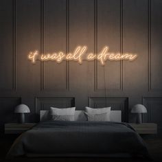 a neon sign that says i was all a dream on the wall above a bed