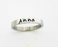 "This GOREOUS 3 mm ring is super shiny, solid stainless steel. Great for stacking. The surface is flat, so the lettering really stands out! Add names, initials, dates, quotes, roman numerals or scripture. I have the heart, double heart, infinity, #, &, @, !, =, *, :, ?, cross, baby foot, angel, and ribbon stamps. Made of solid surgical Stainless steel which will never rust, tarnish, change color and is hypoallergenic. I ONLY stamp on the outside of the rings. I hand stamp each letter, then u Personalized Stackable Rings, Dates Quotes, Personalized Wedding Bands, Ring Name, Hand Stamped Ring, Opal Band, Black Wedding Band, Stamped Rings, Name Ring