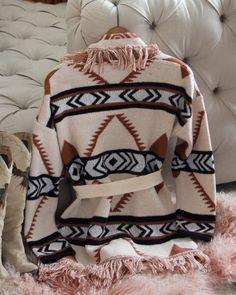 A stunning knit blanket sweater that is perfectly cozy for the season. Open front & soft fringe fold over collar. Color: Cream, camel & black Poly Hand wash cold Model is a size 8 wearing a medium. Small Medium Large Bust 50 52 53 Waist 49 51 52 Hips 51 53 54 Length 31 31 31 Bust, waist, and hip measurements are a total circumference. Length is measured from the top of the shirt to the hem. Measurements are an estimate. Cozy Fringe Outerwear For Fall, Cozy Long Sleeve Outerwear With Fringe, Beige Fringed Winter Outerwear, Cozy Shawl Collar Sweater For Fall, Cozy Fringe Cardigan For Fall, Chic Fringe Sweater For Fall, Fall Tassel Long Sleeve Sweater, Camel Long Sleeve Sweater For Fall, Long Sleeve Camel Sweater For Fall