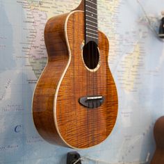 a ukulele hanging on a wall with a map in the backgroud