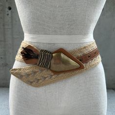 90s jute belt, chunky arrowhead buckle with feathers, vintage summer accessories, tribal fashion statement belt, boho hippie, tribal glam  Transport yourself to the free-spirited vibes of the 90s with our Vintage Jute Belt, a distinctive accessory that effortlessly captures the essence of summer style. This tribal fashion statement belt is a fusion of boho hippie allure and tribal glam, a wearable masterpiece that invites you to embrace the artistry of vintage summer accessories. Crafted from jute, the wide band showcases intricate embroidery in neutral tones, creating a harmonious canvas that tells a story of ethnic elegance. The chunky arrowhead buckle takes center stage, a bold adornment that adds an element of tribal mystique to the belt. Adorned with feathers, it becomes a symbol of f Adjustable Bohemian Belt For Festivals, Bohemian Fabric Belt For Festivals, Embroidered Belt For Summer Beach, Summer Beach Embroidered Belt, Bohemian Brown Belt For Festival, Bohemian Brown Rope Belt, Bohemian Brown Fabric Belt, Bohemian Rope Belt For Summer, Bohemian Adjustable Belts For Summer