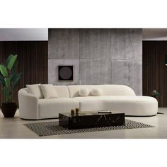 a living room with a large white couch and coffee table in front of a wall