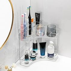 a clear shelf with various cosmetics and personal care items on it in front of a mirror