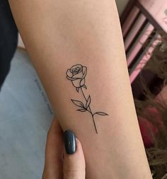 a woman's arm with a rose tattoo on the left side of her body