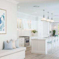 a large kitchen with white cabinets and an island