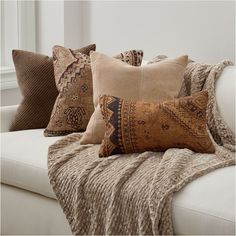 the pillows on the couch are all different shapes and sizes, but one is brown