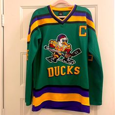 Like New - Mighty Ducks Hockey Jersey! Retro Winter Fan Merchandise Tops, Retro Green Sports Top, Retro Green Tops For Sports, Green Tops For Game Day In Winter, 90s Yellow Long Sleeve Tops, 90s Style Yellow Long Sleeve Tops, Yellow Long Sleeve 90s Tops, Yellow Long Sleeve 90s Style Tops, Green Crew Neck Retro Top