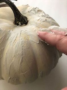 someone is peeling off the top of a white pumpkin