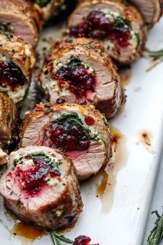 meat with cranberry sauce and herbs on a cutting board