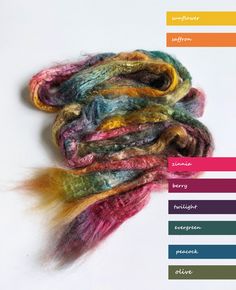 there are many different colored yarns on the table together, including one with multi - colored hair