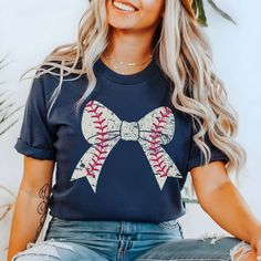 🌟 Knock it out of the park with our Baseball Large Bow Bella Tee! 🌟 Gear up for game day in style with our Baseball Large Bow Bella Tee, the perfect blend of sporty chic and feminine flair. Crafted from premium, ultra-soft fabric, this tee is as comfortable as it is stylish, making it the ideal choice for cheering on your favorite team from the stands or enjoying a casual day out with friends. The standout feature? A large bow, right on trend with baseball stitching, adding a touch of playful Spring Sports Event Tops, Collegiate Tops For Spring Sports Events, Collegiate Tops For Sports Events In Spring, Collegiate Style Tops For Spring Sports Events, Sporty Tops For Game Day, Team-colored Tops For Baseball Season Game Day, Team-colored Tops For Baseball Game Day, Team-colored Tops For Game Day During Baseball Season, Spring Sports T-shirt Pre-shrunk