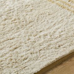 a white rug on top of a wooden floor next to a wood flooring board