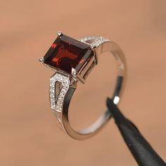 It is a natural garnet ring. The main stone is 7 mm*9 mm emerald cut.weight about 3.04 carats.The basic metal is sterling silver and plated with rhodium.To change the metal to a solid gold (white/rose) or platinum is also available, please ask for a quotation if you want.You can also go to my shop Home for more elegant rings: https://www.etsy.com/shop/godjewelry?ref=hdr_shop_menu Garnet is January birthstone More garnet rings:https://www.etsy.com/shop/godjewelry?ref=seller-platform-mcnav&sec Emerald Cut Ruby Ring With Accent Stones As Gift, Classic Emerald Cut Ruby Ring As Gift, Classic Garnet Jewelry With Halo Setting, Elegant Garnet Birthstone Ring With Center Stone, Classic Emerald-cut Sterling Silver Birthstone Ring, Classic Emerald Cut Sterling Silver Birthstone Ring, Classic Emerald-cut Birthstone Ring In Sterling Silver, Classic Emerald Cut Birthstone Ring In Sterling Silver, Classic Garnet Diamond Ring Gift