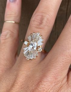 a woman's hand with a ring on it and an engagement ring in the middle