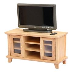 a small wooden entertainment center with a flat screen tv on it's top shelf