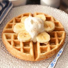 a waffle topped with bananas and whipped cream