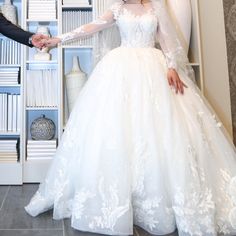 a woman in a wedding dress is holding the hand of a man wearing a tuxedo