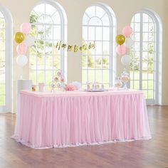 a pink and gold birthday party with balloons, streamers, cake and dessert table