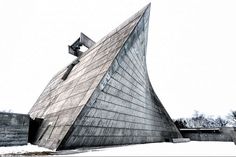 a large triangular shaped building sitting on top of snow covered ground