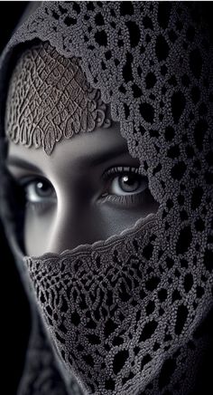 a woman's face is covered by a shawl with lacy crochet