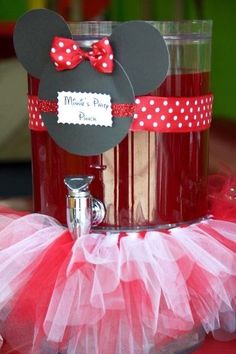 a minnie mouse party centerpiece on top of a table with red and white tulle