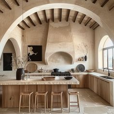 a large kitchen with an arched ceiling and marble counter tops, along with wooden stools