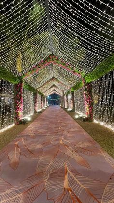 an outdoor walkway decorated with lights and flowers