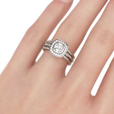 a woman's hand with a white diamond ring on top of her finger,