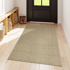 a door way with a rug on the floor next to it and shoes near by