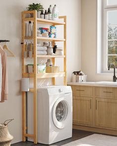 a washer sitting next to a dryer in a room with wooden cabinets and shelving