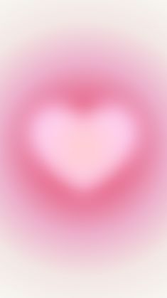 a blurry image of a heart shaped object in pink and white with the light reflecting off it's side