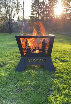 a fire pit sitting on top of a lush green field