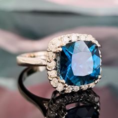 a ring with a blue stone surrounded by diamonds