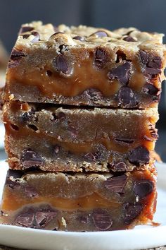 three pieces of chocolate chip cookie bars stacked on top of each other in front of the camera