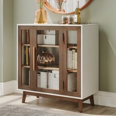 a wooden cabinet with glass doors and baskets in front of a mirror on the wall