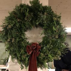 a green wreath with a red bow hanging from it