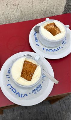 two white plates topped with dessert sitting on top of a red table next to each other