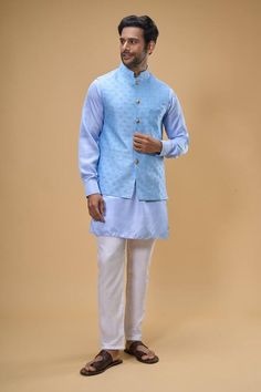 Sky blue sleeveless bundi crafted in dupion silk with sequin floret quad embroidery. Paired with a solid ice blue kurta and a white pant. - Aza Fashions Blue Sleeveless Kurta For Festive Occasions, Festive Sleeveless Blue Kurta, Festive Blue Sleeveless Kurta, Traditional Sleeveless Blue Kurta, Blue Cotton Nehru Jacket For Wedding, Fitted Cotton Nehru Jacket With Gota Work, Blue Chanderi Nehru Jacket For Designer Wear, Blue Cotton Nehru Jacket For Festive Occasions, Festive Blue Cotton Nehru Jacket