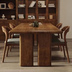 a wooden table with chairs around it in front of bookshelves and shelves filled with books