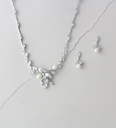 "This decorative floral design made of diamond white freshwater pearls and Cubic Zirconia marquise cut stones is absolutely stunning. Paired with matching silver earrings this bridal set is whimsical and delicate, perfect for your wedding day! Size: 17\" (Necklace Length) 1/4\" (Necklace Width) 1\" (Necklace Drop) 2\" (Earrings Length) 1/4\" (Earrings Width) Also available with backdrop. Please choose style from drop down menu. Matching bracelet: https://www.etsy.com/listing/174590562/bridal-fre Elegant Cubic Zirconia Necklace For Mother Of The Bride, Elegant White Pearl Drop Jewelry Sets, Elegant Cubic Zirconia Jewelry For Mother Of The Bride, Elegant Pearl White Jewelry Set With Pearl Pendant, White Pearl Drop Jewelry Sets, Elegant Bridal Necklace With Pearl Drop And Cubic Zirconia, Elegant Pearl Drop Jewelry Set With Cubic Zirconia, Elegant White Jewelry Sets With Pearl Pendant, Elegant White Bridal Necklace With Matching Earrings