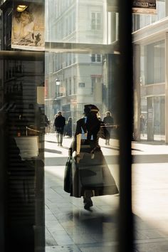 a woman is walking down the street carrying shopping bags