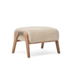 the foot stool is made from wood and has a beige upholstered fabric on it