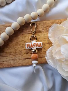 a wooden bead necklace with the word mama on it and two beads attached to it