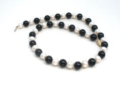 Fine Gemstone Jewelry - This is a classic necklace with polished black onyx beads and genuine pearls. The beads are 10mm (.38") wide, 18" long, clasp is hallmarked 14K. Classic Black Necklaces With 8mm Beads, Formal Black Necklace With Gemstone Beads, Classic Black Single Strand Beaded Necklace, Classic Black Beaded Necklace With Polished Beads, Classic Black Beaded Necklaces With Polished Beads, Classic Single Strand Onyx Necklace, Black Single Strand Pearl Necklace, Classic Black Beaded Necklaces, Classic Onyx Single Strand Necklace