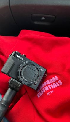 a camera sitting on top of a red shirt