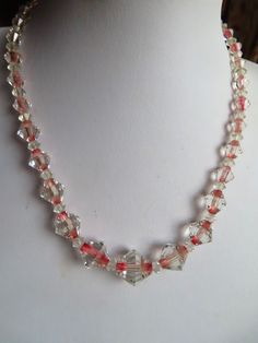 "1950's Unusual Clear with Pink middle Glass Bead Necklace - A lovely Bi-cone shaped necklace clear with a pink middle and has a sterling silver roll over fastener. This necklace is 16.5 inches long.   The main bead is 3/4\" wide and they graduate either side. This necklace is in a good condition." Vintage Handmade Clear Jewelry, Vintage Pink Single Strand Jewelry, Vintage Pink Faceted Bead Jewelry, Vintage Clear Necklace For Wedding, Vintage Handmade Clear Necklace, Vintage Clear Crystal Necklace, Vintage Crystal Beaded Necklaces For Gift, Vintage Clear Glass Necklaces, Vintage Clear Round Necklace