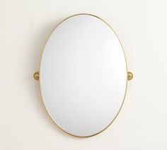 an oval mirror mounted on the wall