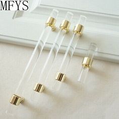 five pieces of clear acrylic with gold colored metal fittings on the bottom